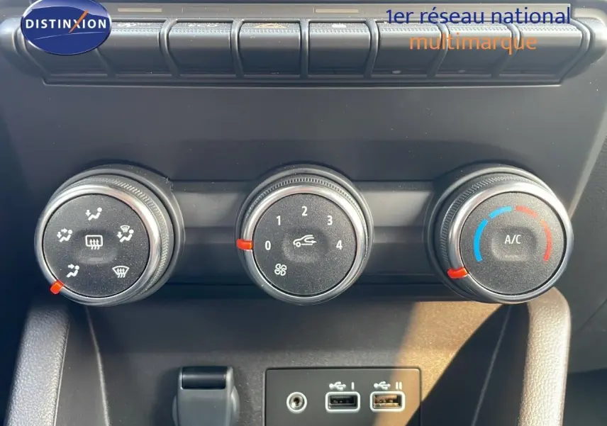Commandes de climatisation avec trois boutons rotatifs et ports USB dans une Renault Clio gris schiste 2025.