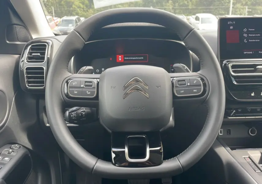Vue centrée sur le volant Citroën C5 Aircross Hybrid 2025, avec tableau de bord numérique et écran tactile visible.