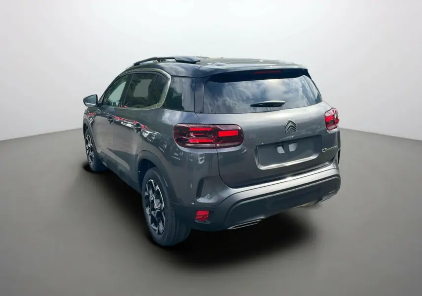 Vue 3/4 arrière gauche du Citroën C5 Aircross 2025 gris platinium avec toit noir et feux arrière LED distinctifs.