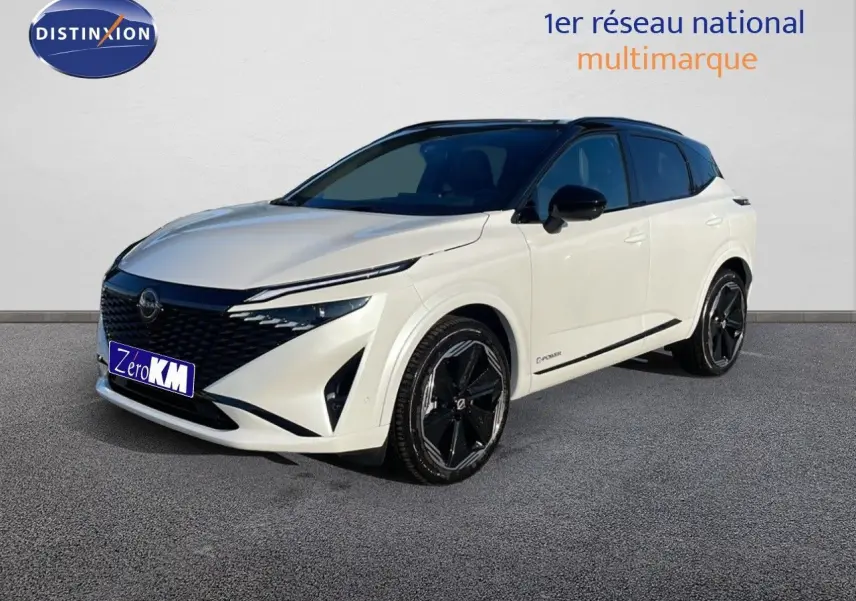 Nissan Qashqai blanc nacré avec toit noir en 3/4 avant droit, mettant en valeur ses jantes noires et calandre distinctive.