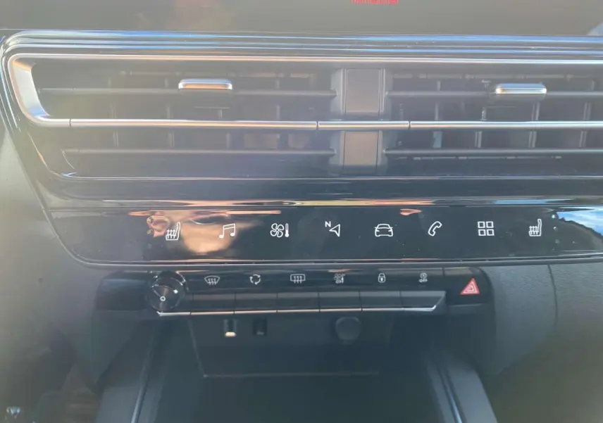 Détail du tableau de bord noir brillant du Citroën C5 Aircross 2025 avec commandes tactiles et aérateurs horizontaux.