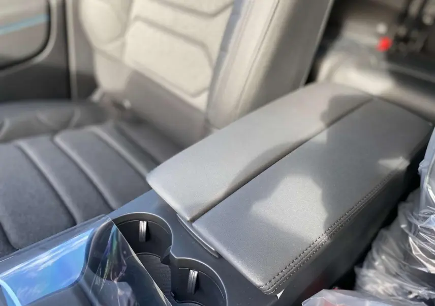 Gros plan sur l'accoudoir central arrière en cuir gris du Citroën C5 Aircross 2025 noir Perla.