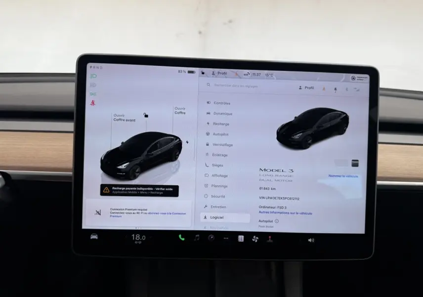 Écran tactile central affichant les réglages d'une Tesla Model 3 noire, vue intérieure du tableau de bord.