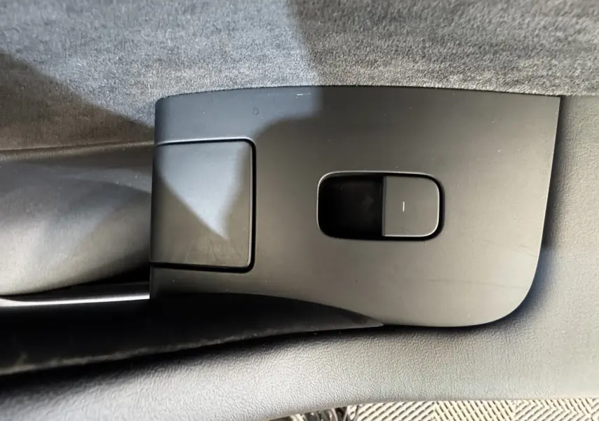 Gros plan sur le bouton de réglage électrique du siège côté conducteur intérieur d'une Tesla Model 3 noire 2023.