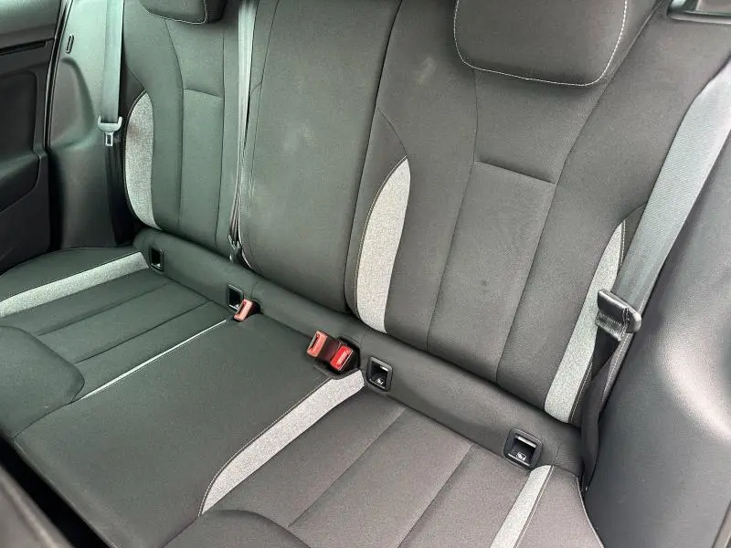 Vue rapprochée de la banquette arrière en tissu noir et gris clair de la Skoda Scala 2025, avec ceintures de sécurité visibles.