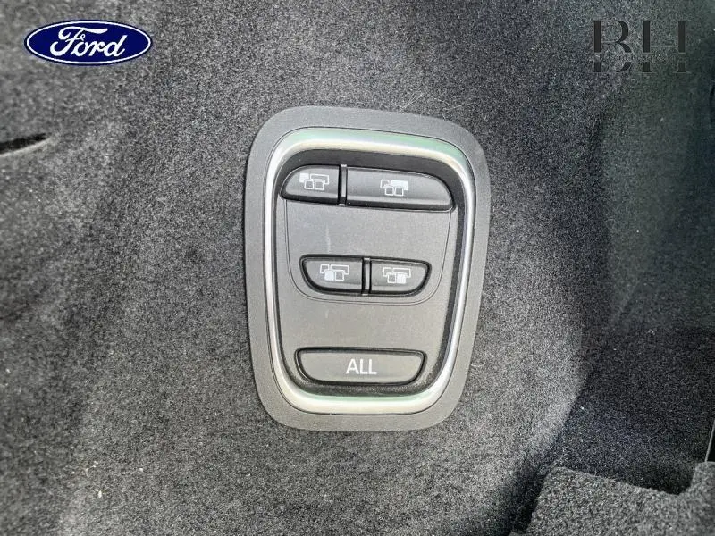 Boutons de commande des sièges arrière rabattables sur moquette noire à l'intérieur du Renault Grand Scenic noir étoilé 2021.