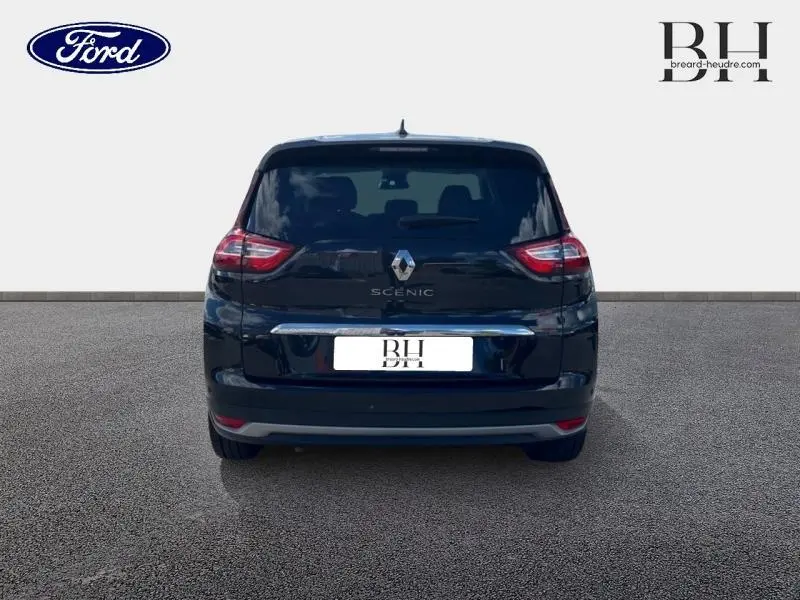 Vue arrière d'un Renault Grand Scenic noir étoilé, avec feux arrière allongés et logo central visible.