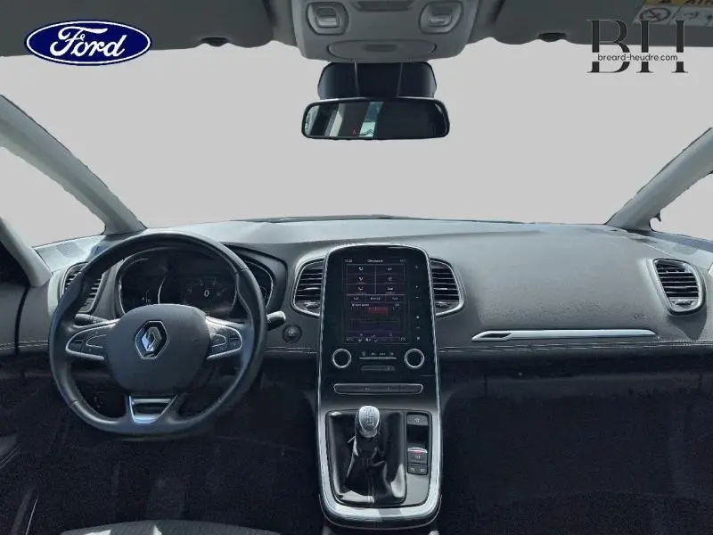 Vue frontale de l'habitacle noir étoilé du Renault Grand Scenic 1.3 TCe 140ch avec écran tactile et volant cuir.