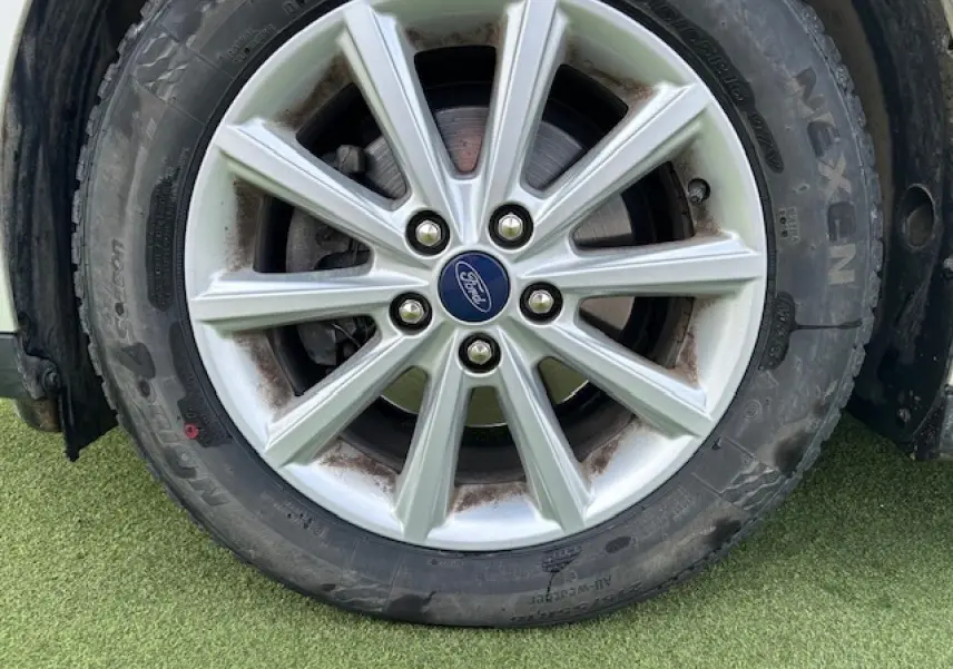 Gros plan sur la jante alliage 16 pouces 10 branches argentée avec logo Ford au centre sur pneu toutes saisons.