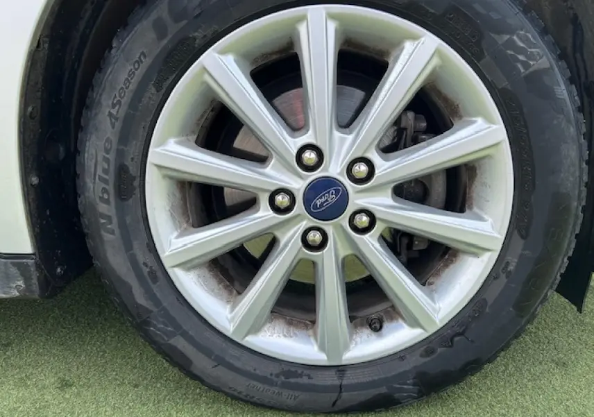 Gros plan sur la jante alliage 16 pouces 10 branches et pneu toutes saisons d'une Ford C-MAX gris clair métal.