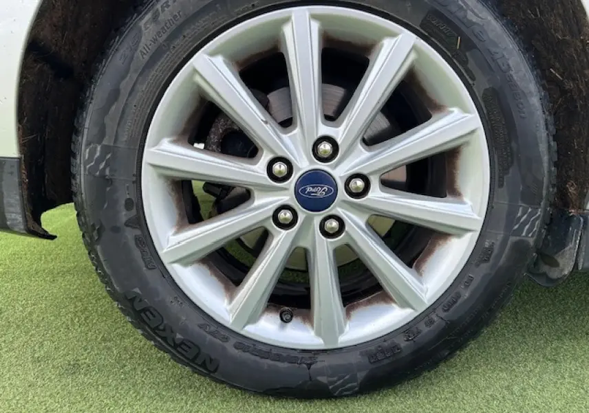 Gros plan sur la jante alliage 16 pouces à 10 branches avec logo Ford sur pneu toutes saisons d’un Ford C-MAX gris clair.