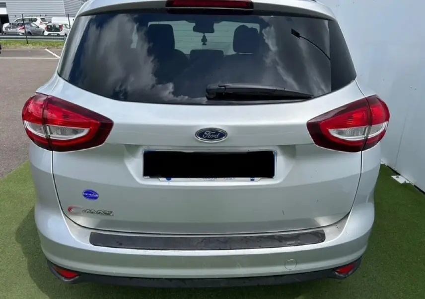 Vue arrière du Ford C-MAX gris clair métal avec vitres arrière surteintées et feux rouges distinctifs.