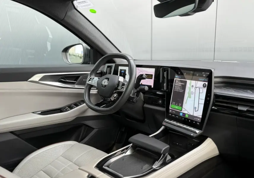 Vue intérieure côté conducteur du Renault Espace VI hybride, avec sellerie cuir gris sable clair et écran tactile vertical.