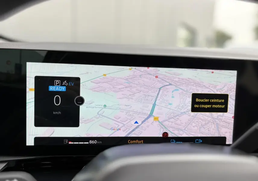Affichage du tableau de bord numérique du Renault Espace VI hybride, montrant la navigation et les alertes de sécurité.