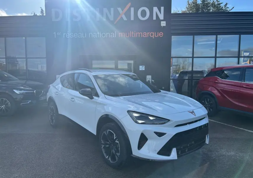 Vue 3/4 avant droite d'une CUPRA Formentor blanc neige avec jantes alliage 18'' et toits noir piano en arrière-plan showroom.