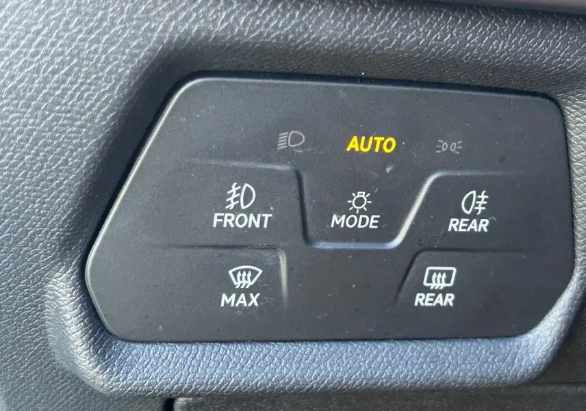 Gros plan sur les commandes d’éclairage intérieures noires du CUPRA Formentor blanc neige, avec indication AUTO allumée.