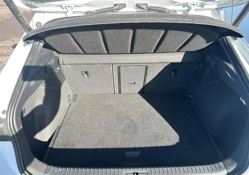 Coffre ouvert vu de l'arrière d'une CUPRA Formentor blanc neige, avec banquette arrière rabattable et cache-bagages.