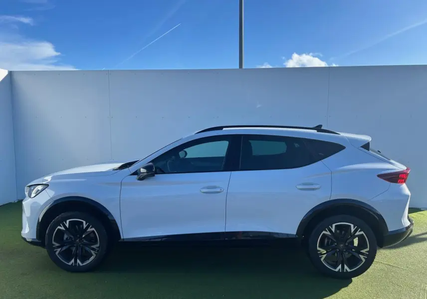 Vue de profil côté gauche du CUPRA Formentor blanc neige 2025 avec jantes alliage noires et éléments noirs contrastants.