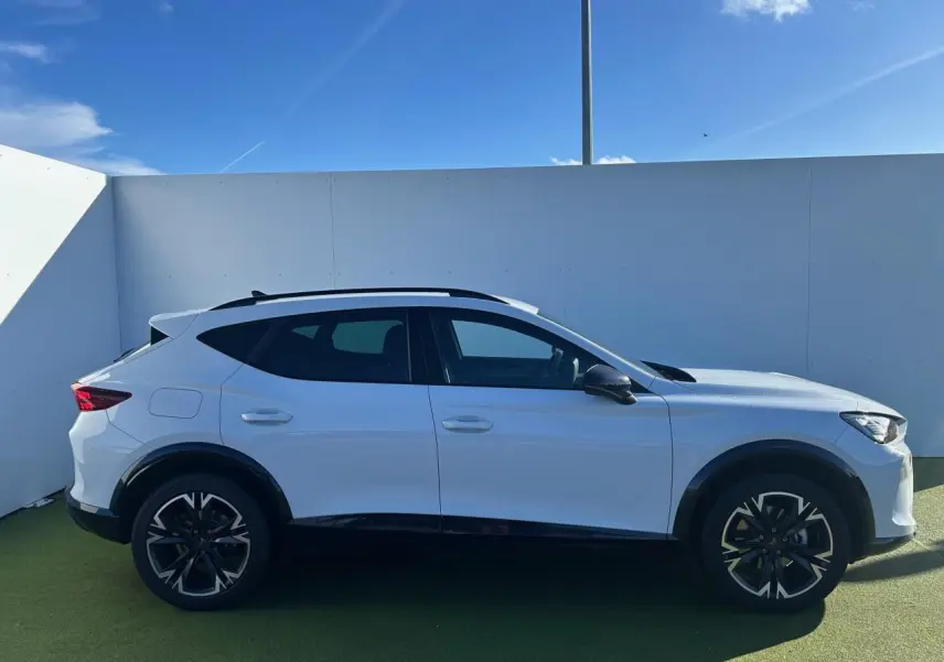 Vue latérale droite d'un CUPRA Formentor blanc neige avec jantes alliage 18'' et bas de caisse noir obsidien.