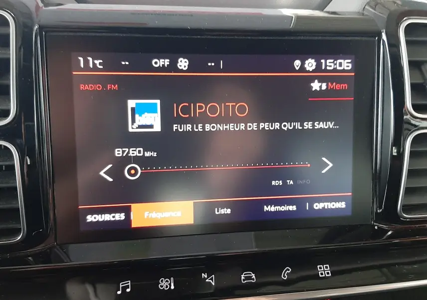 Vue rapprochée de l’écran tactile central du Citroën C5 Aircross gris Artense, affichant la radio FM à 87,60 MHz.