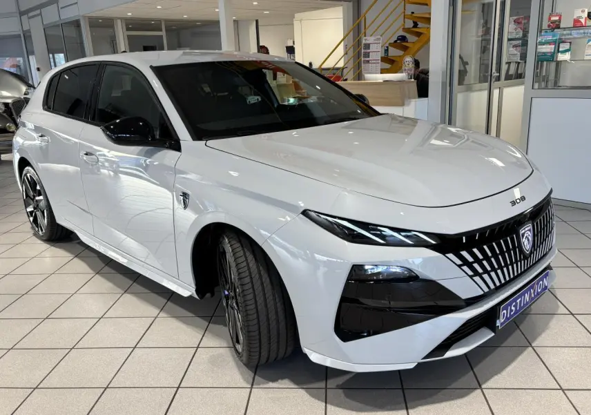 Peugeot 308 blanc Okenite vue 3/4 avant droit, calandre noire distinctive et jantes alliage bi-ton.