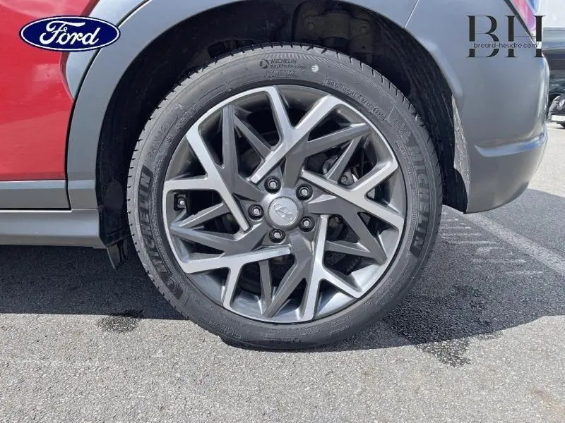 Gros plan sur la roue avant gauche avec jante alu gris foncé du Hyundai Kona Pulse Red Métal 2021.
