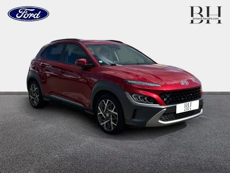 Hyundai Kona hybride Pulse Red Métal en 3/4 avant droit avec jantes alliage et détails noirs contrastants.