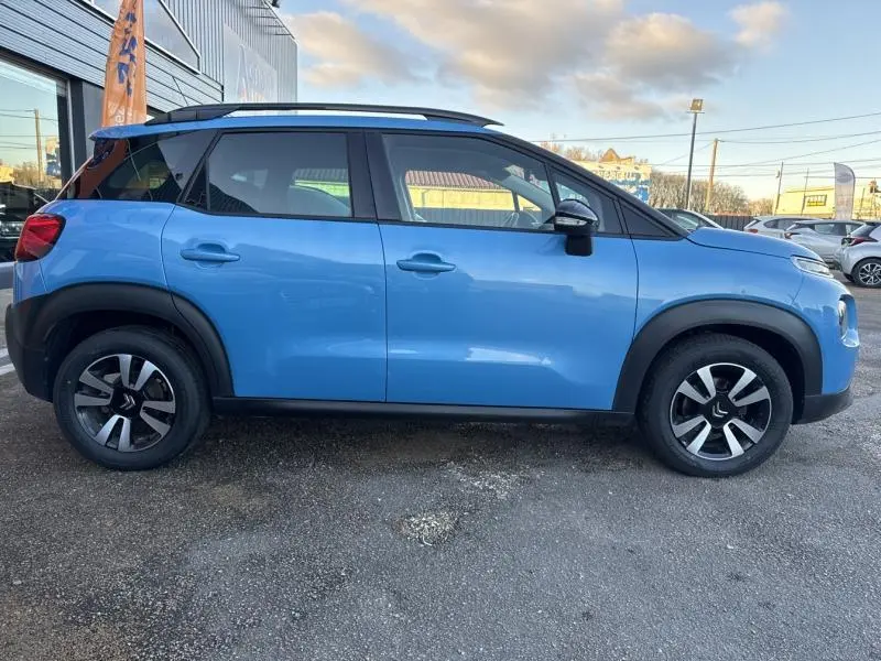 Profil côté gauche d'un Citroën C3 Aircross 2021 bleu Breathing avec jantes alliage et barres de toit noires.