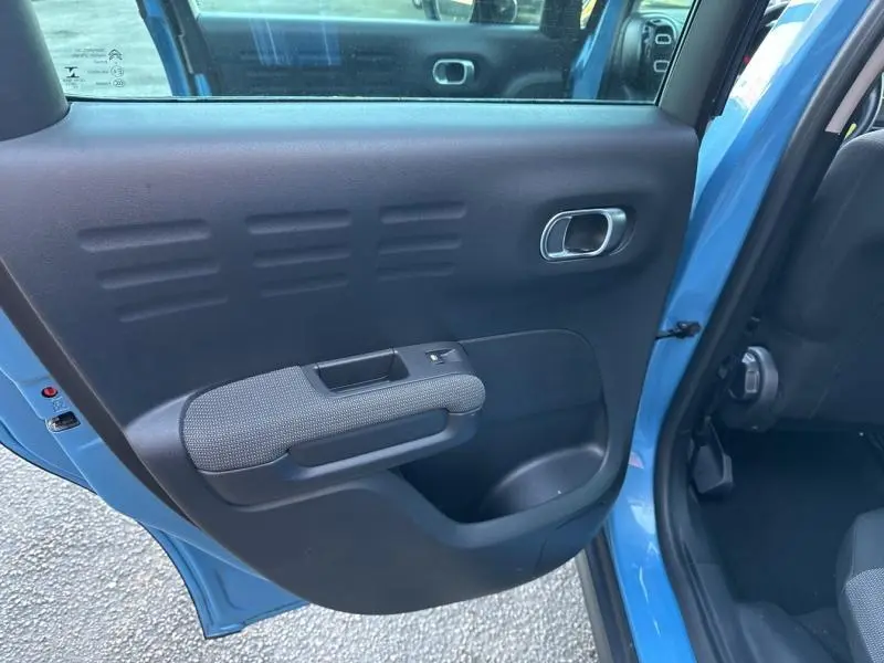 Vue intérieure de la porte arrière gauche bleue Breathing Blue du Citroën C3 Aircross 2021 avec poignée et commande de vitre.