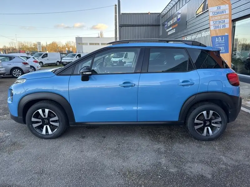 Profil côté gauche d'un Citroën C3 Aircross 2021 bleu Breathing avec toit noir et jantes alliage 16 pouces.