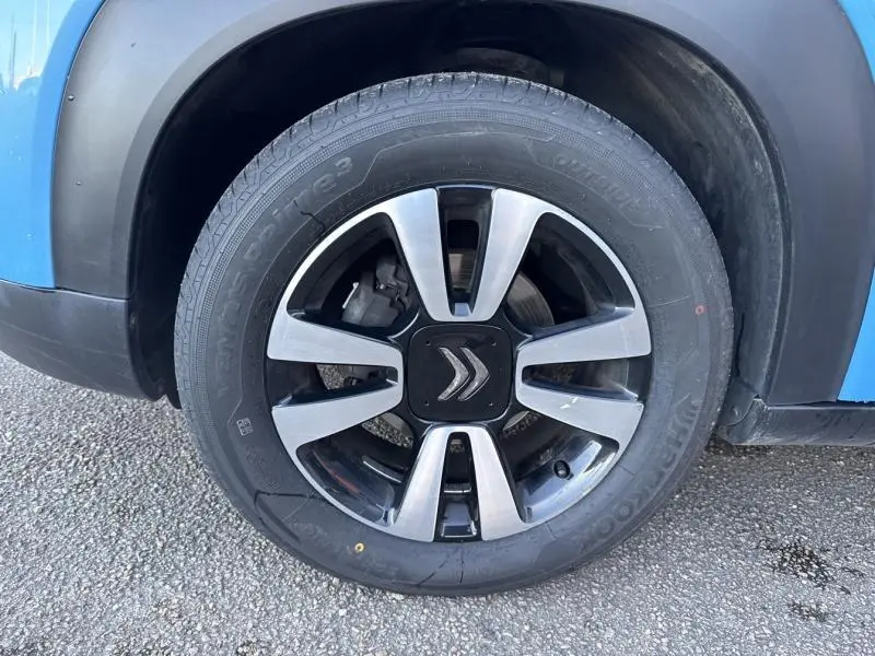 Gros plan sur la jante alu 16 pouces Matrix diamantée noire et argent du côté avant droit d'une Citroën C3 Aircross Breathing Blue.