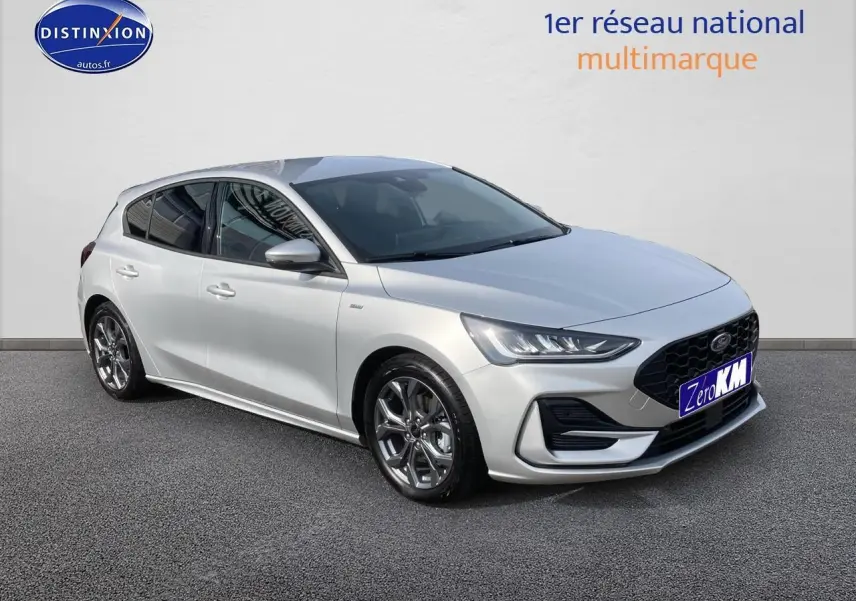 Ford Focus gris clair vue 3/4 avant droit avec calandre noire et jantes alu 17 pouces brillantes