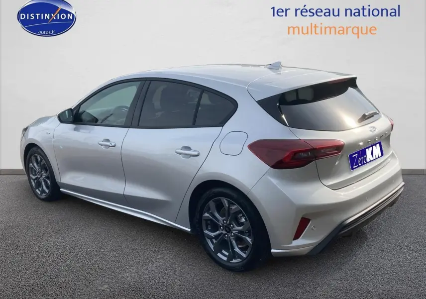 Vue 3/4 arrière droite d'une Ford Focus gris clair avec jantes alu 17 pouces et vitres arrière surteintées.