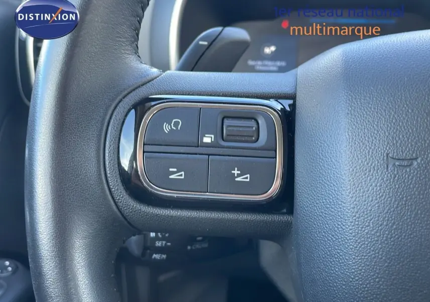 Gros plan sur les commandes gauche du volant noir du Citroën C5 Aircross blanc nacré hybride 2021.