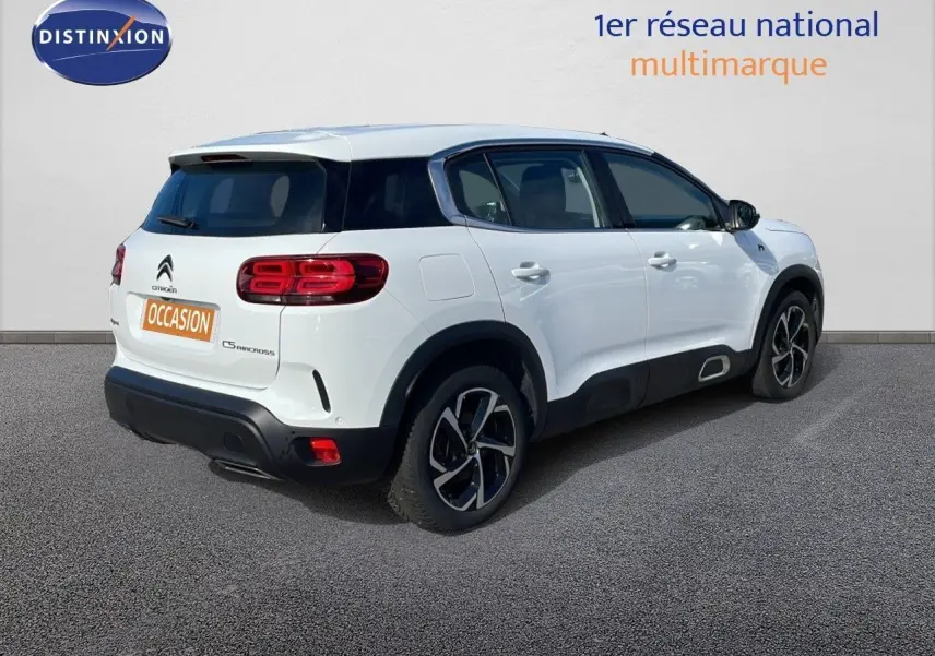 Vue 3/4 arrière droite d'un Citroën C5 Aircross blanc nacré avec jantes bi-ton et toit noir contrasté.