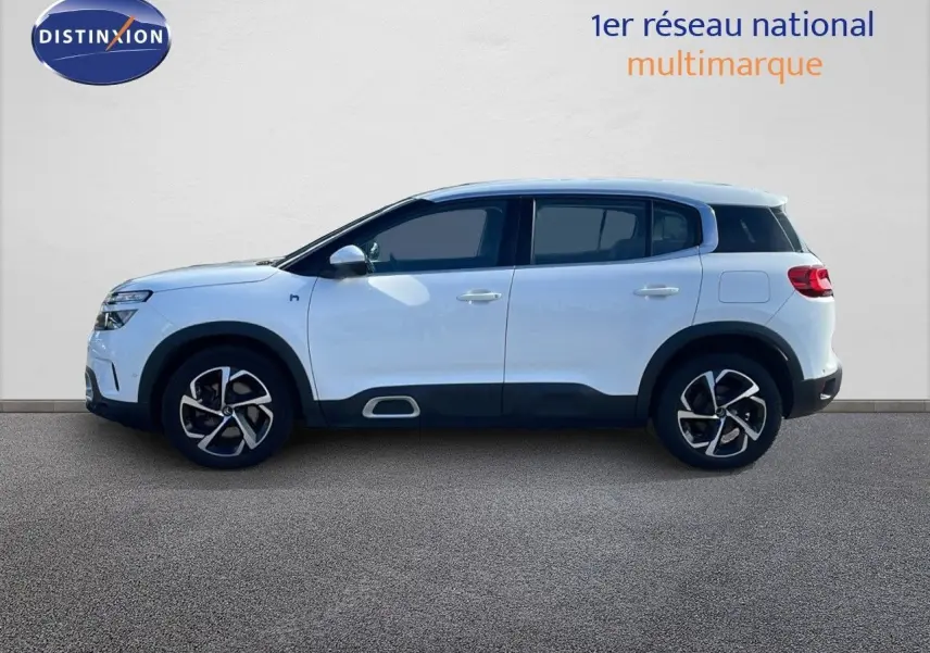 Profil droit d'un Citroën C5 Aircross blanc nacré avec jantes bi-ton et protections noires sur bas de caisse.