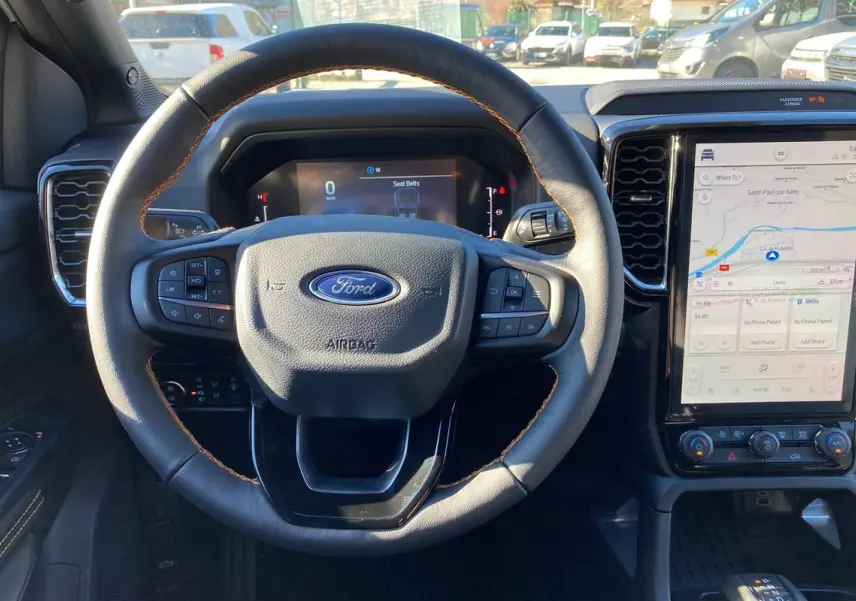 Vue intérieure centrée sur le volant du Ford Ranger 2025 avec tableau de bord digital et écran tactile vertical.
