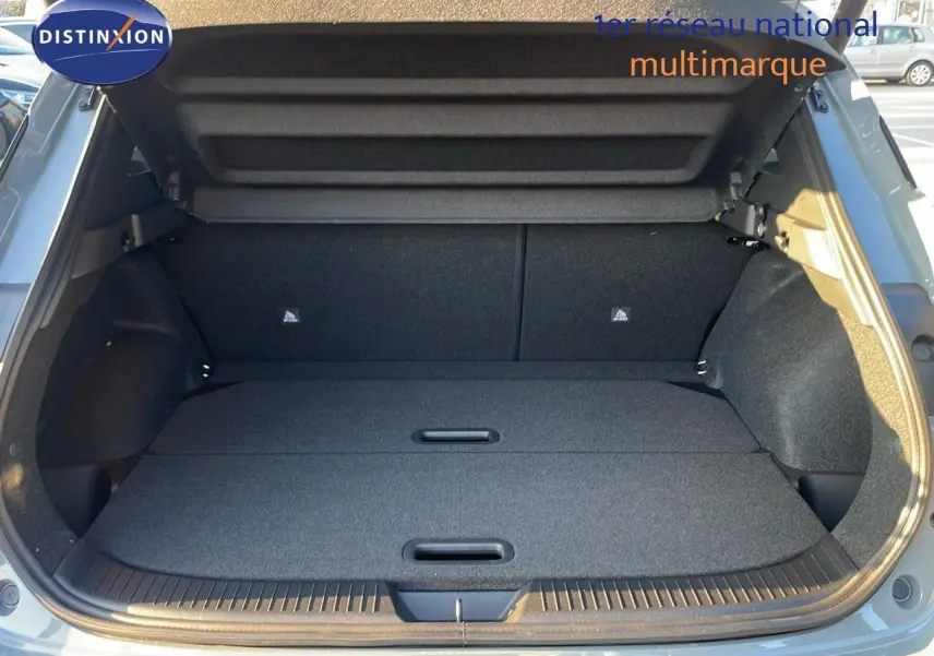 Coffre ouvert du Nissan Qashqai 2025 gris céramique métal, vue arrière montrant un espace de chargement plat et spacieux.