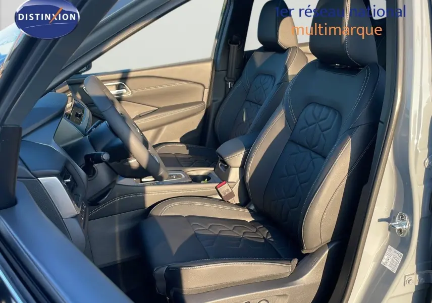 Intérieur du Nissan Qashqai 2025 gris céramique, vue côté conducteur sur sièges cuir noir avec surpiqûres blanches.