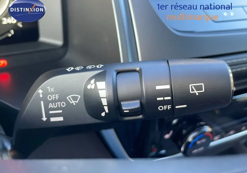 Gros plan sur la commande d’essuie-glace du Nissan Qashqai 2025 gris céramique, avec tableau de bord en arrière-plan.