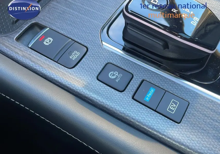 Gros plan sur la console centrale du Nissan Qashqai 2025 gris céramique, montrant les boutons e-Pedal et frein électronique.