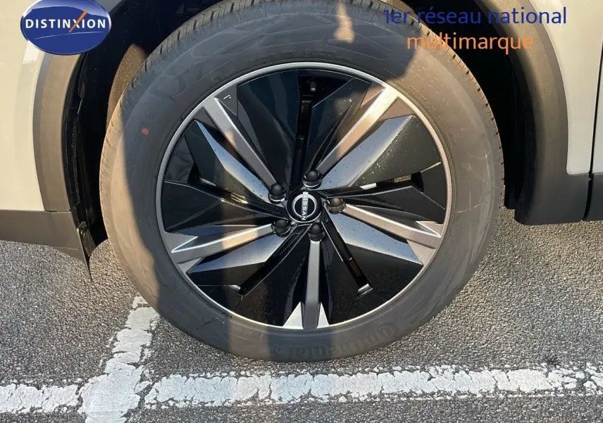 Gros plan sur la jante noire et grise du Nissan Qashqai 2025 gris céramique métal, avec logo Nissan visible au centre.