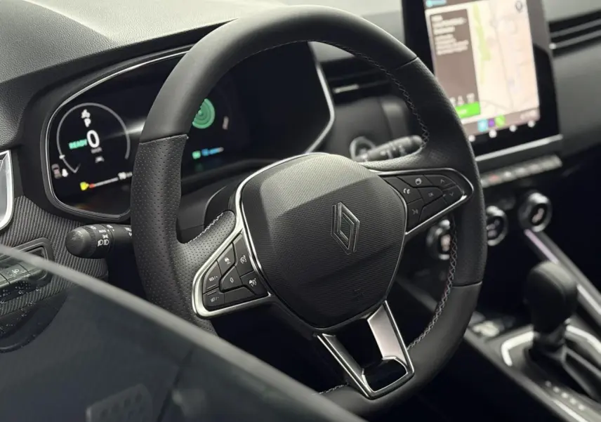 Vue rapprochée du volant multifonction noir de la Renault Clio V NV E-Tech 2025 avec tableau de bord numérique et écran tactile.