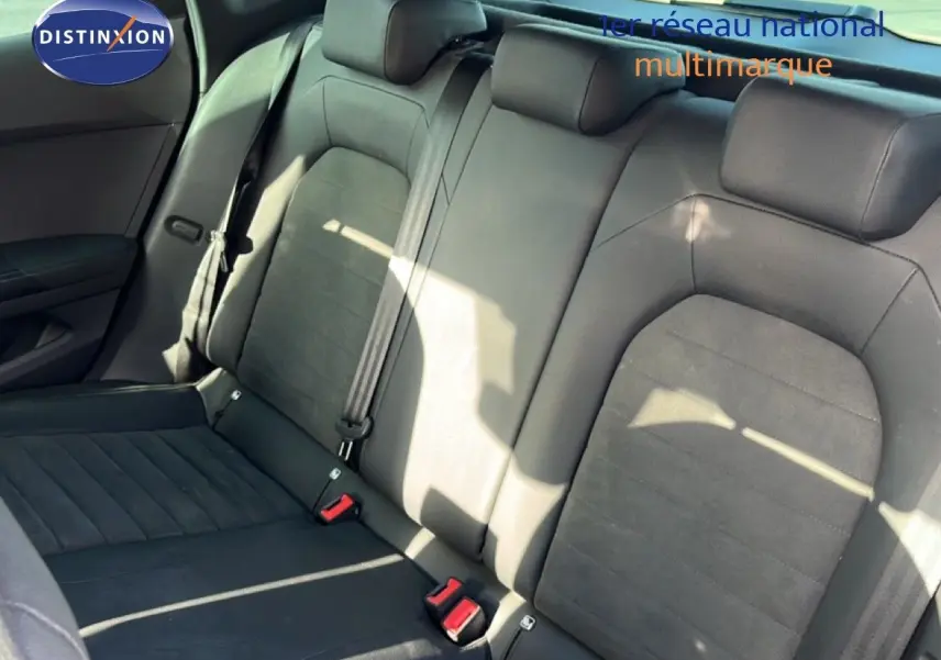 Vue intérieure montrant la banquette arrière en tissu noir du SEAT Arona 2025, avec ceintures de sécurité et appuie-têtes.