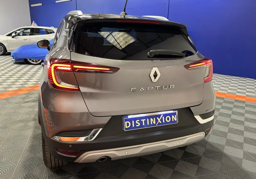 Vue arrière d’un Renault Captur gris 2020 avec feux LED allumés dans un showroom au sol damier.