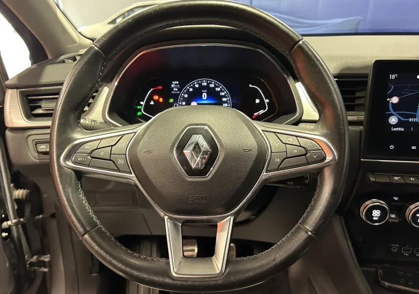 Vue rapprochée du volant en cuir noir du Renault Captur 2020 avec tableau de bord numérique et écran GPS visible à droite.