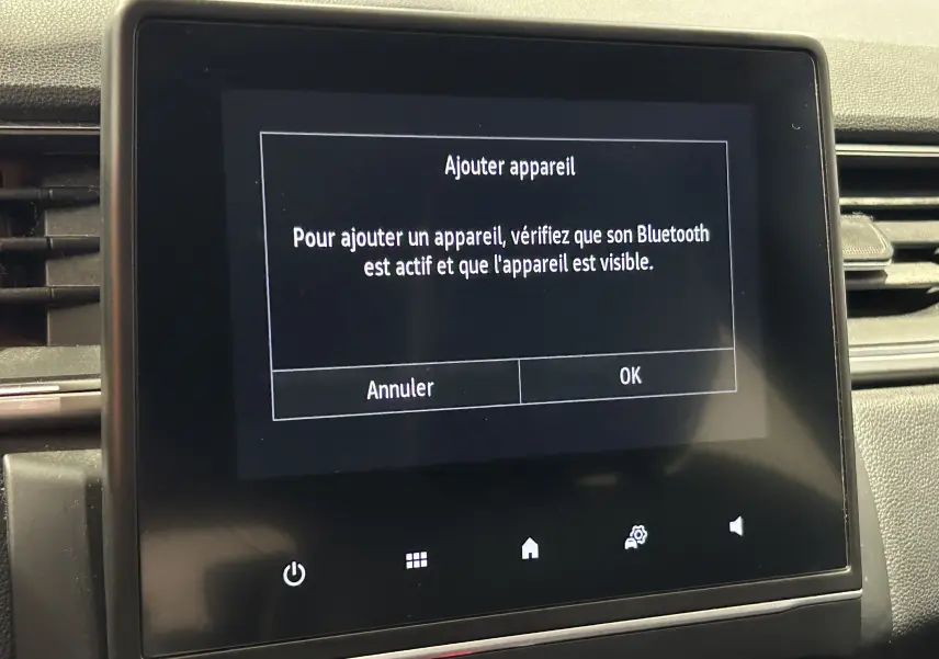 Écran tactile central du tableau de bord du Renault Captur 2020 affichant un message d'ajout Bluetooth.