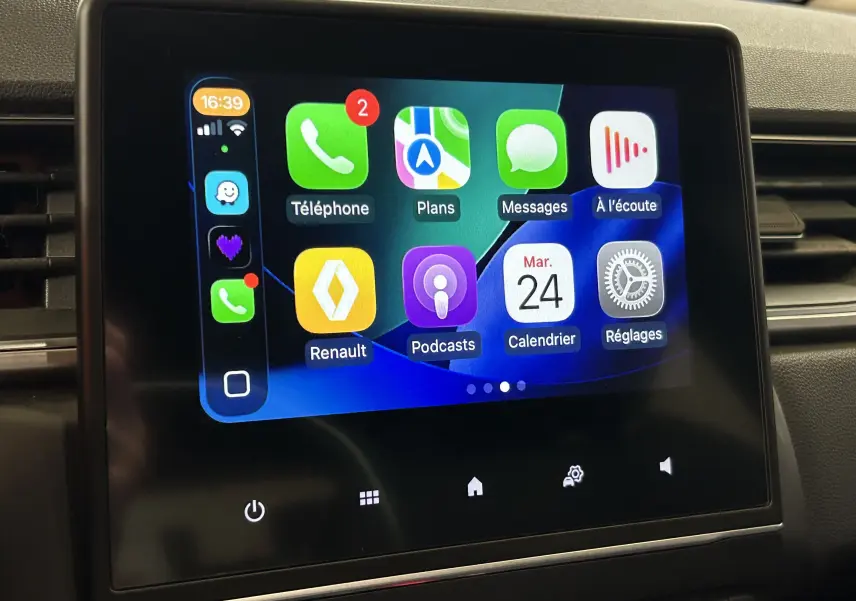 Écran tactile central affichant l'interface Apple CarPlay dans l'habitacle d'un Renault Captur gris.