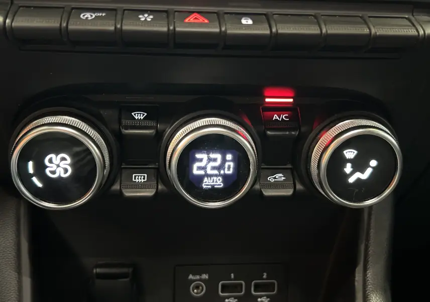 Gros plan sur les commandes de climatisation du Renault Captur gris 2020, avec affichage digital à 22°C et bouton A/C allumé.