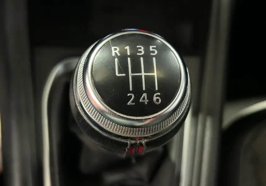 Gros plan sur le pommeau de la boîte manuelle noire du Renault Captur 2020, avec marquage des vitesses en blanc.